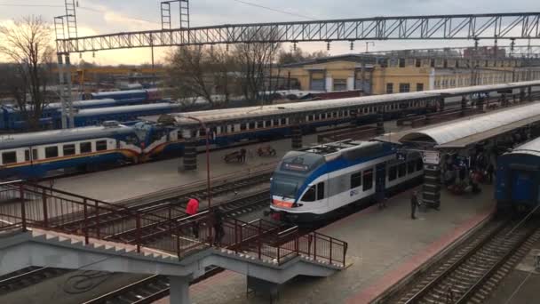 Gomel, Bielorussia - 18 aprile 2018: persone che salgono in treno sulla piattaforma della stazione. Treni e Stazione ferroviaria Edificio — Video Stock