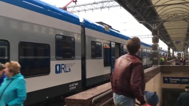 Гомель, Беларусь - 18 апреля 2018 года: Люди идут рядом с поездами на платформе железнодорожного вокзала — стоковое видео