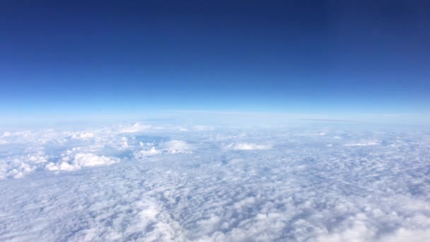 Mooi uitzicht vanuit de lucht op heldere lucht boven witte pluizige wolken vanuit de hoogte vlucht van het vliegtuig — Stockvideo