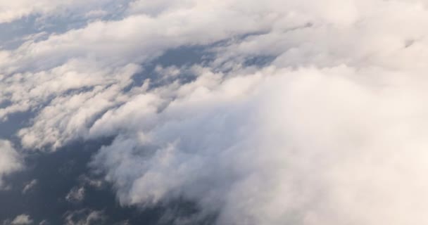 Hermosa vista aérea del cielo despejado sobre nubes esponjosas blancas desde el vuelo de altura del avión — Vídeos de Stock