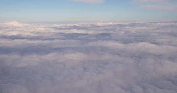 Hermosa vista aérea del cielo despejado sobre nubes esponjosas blancas desde el vuelo de altura del avión — Vídeo de stock