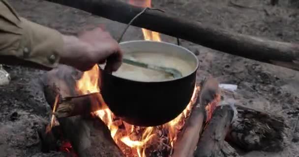 Старый ретро лагерь кастрюля кипяченая вода для приготовления супа на пожаре в лесу. Огненный костер в летний вечер — стоковое видео