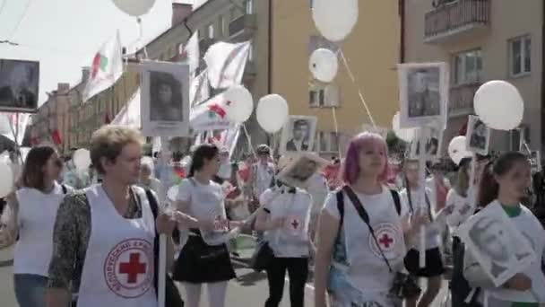 Gomel, Valko-Venäjä - 9. toukokuuta 2018: Kuolematon rykmentti marssi Punaisen Ristin ihmisten paraatissa toisen maailmansodan sankarien muotokuvien kanssa. Vuosittainen Victory Day Celebration 9 Toukokuu — kuvapankkivideo