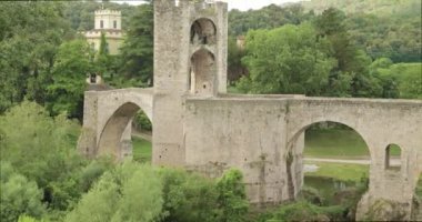 Besalu, Girona, Katalonya, İspanya. Ünlü Ortaçağ Romanesk Besalu Köprüsü Fluvia Nehri üzerindeki Bulutlu Yaz Günü