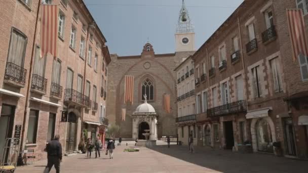 Perpignan, Franciaország - Lehet 16, 2018: Emberek séta Leon Gambetta tér és katedrális Szent János a keresztelő Perpignan a napsütéses nyári napon — Stock videók