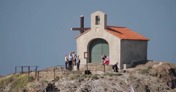 Collioure, França - 16 de maio de 2018: Turistas descansam e caminham na costa perto da Capela de São Vicente na ensolarada Primavera da Europa — Vídeo de Stock