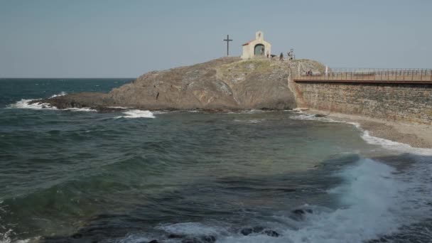 Collioure, France. Волны Средиземного моря, омывающие побережье возле часовни Святого Винсента в солнечный весенний день — стоковое видео