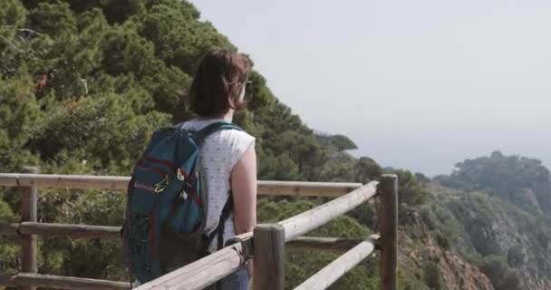 Tossa De Mar, Girona, Spain. Балеарське море. Жіночий турист з рюкзаком Захоплюючий погляд на іспанську природу з літнім скелястим ландшафтом — стокове відео