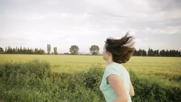 Fiatal kaukázusi lány nő élvezi az életet, és fut kocogás a spanyol vidéki úton keresztül vidéki búza mező táj. — Stock videók