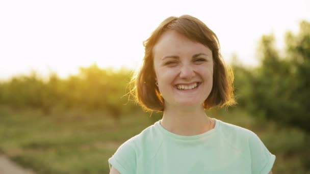 Каталония, Испания. Молодая позитивная белая девушка наслаждается жизнью и смеется перед камерой на испанской сельской дороге через сельский пейзаж пшеничного поля — стоковое видео