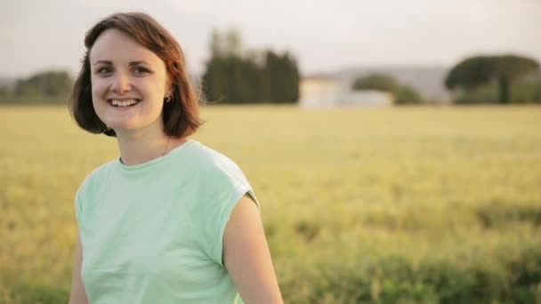 Joven mujer caucásica disfrutando de la vida y caminando por el paisaje rural del campo de trigo — Vídeos de Stock