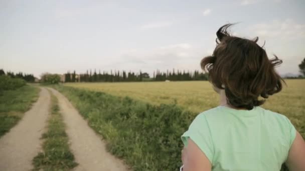 Jonge blanke vrouw die geniet van het leven en hardlopen in het Spaanse platteland Road Through Rural Wheat Field — Stockvideo