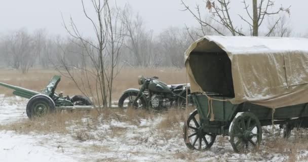 Abandonné l'équipement soviétique russe et les véhicules de la Seconde Guerre mondiale. Pistolet antichar soviétique russe de 45mm, vieille moto à trois roues tricar et chariot paysan en hiver journée enneigée — Video