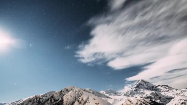 Stepantsminda, Georgia. Noche de invierno Cielo estrellado con estrellas brillantes y pico del monte Kazbek cubierto de nieve. Hermosa noche georgiano paisaje de invierno — Vídeos de Stock