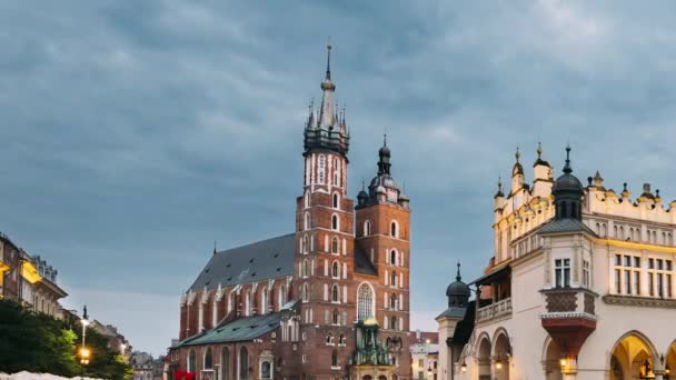 Krakau, Polen. Nachtzicht op St. Marys Basiliek en het Lakenhal gebouw. Beroemde oude herkenningkerk van Onze Lieve Vrouw in de Hemel. UNESCO Werelderfgoed — Stockvideo