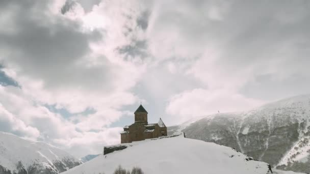 Stepantsminda, Gergeti, Georgia. Famosa Gergeti Trinity Tsminda Sameba Iglesia en el paisaje de invierno — Vídeos de Stock