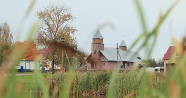 Porplischte, Bezirk Dokschizy, Gebiet Witsebsk, Weißrussland. Alte katholische Holzkirche der Jungfrau Maria im Herbst — Stockvideo