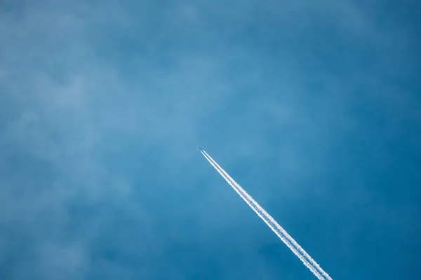 Contrail In Blue Sky. Plane In Sunny Sky Background. Airplane Aircraft In Sky With Trails
