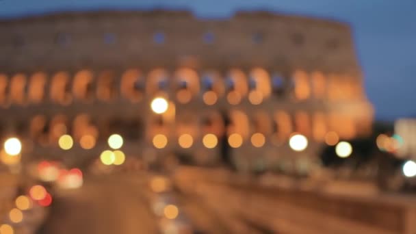 Rome, Italië. Het Colosseum. Verkeer in Rome In de buurt van beroemde wereldmijlpaal in de avond. Abstract Wazige achtergrond. wazige boke bokeh achtergrond. — Stockvideo