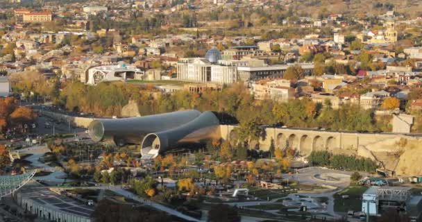 Tbilissi, Géorgie. Vue du dessus des monuments célèbres en soirée d'automne. Capitale géorgienne Paysage urbain Skyline. Pont De Paix, Salle De Concert, Rike Park Et Palais Présidentiel . — Video