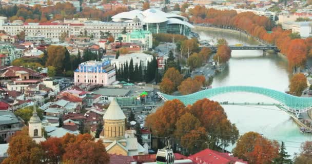 Tbilisi w Georgii. Top View Of Famous Zabytki Jesienią wieczorem. Gruzińska stolica Skyline Cityscape. Most Pokoju, Sala Koncertowa, Rike Park. Kolejka linowa wokół rzeki Kura — Wideo stockowe