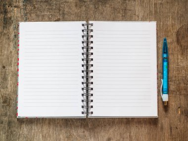 ahşap masa üstünde kalem ile defter