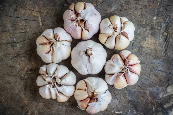 Garlic for cooking on old wooden background.