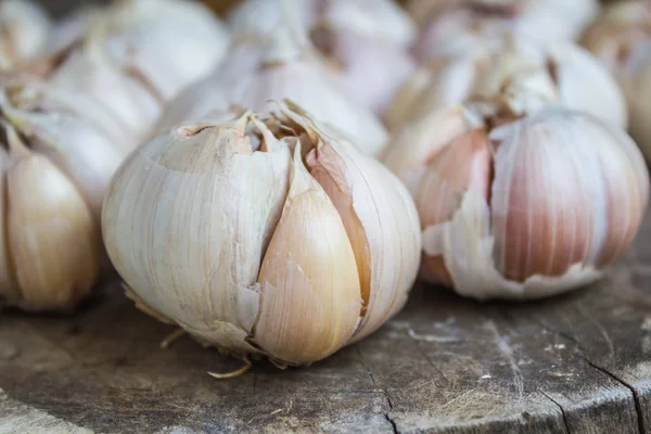 Garlic for cooking on old wooden background.