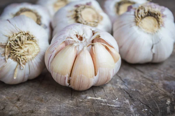 Garlic for cooking on old wooden background.