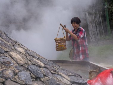 Taiping Mountain, Taiwan - October 15, 2016: Eggs and vegetables being cooked  in  the water of hot springs in Taiwan clipart