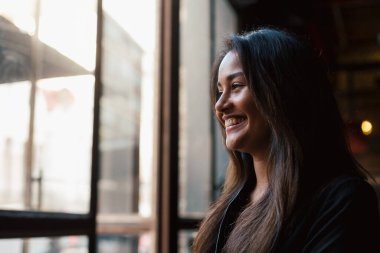 Genç melez kız kahve masasında oturuyor. 