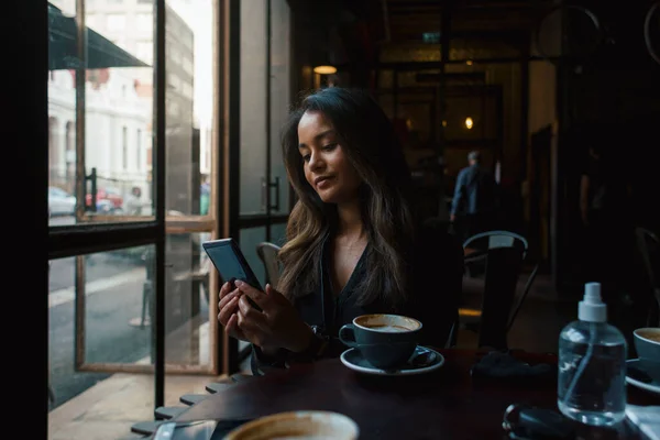 Jong Gemengd Ras Meisje Met Smartphone Zitten Aan Tafel Met — Stockfoto