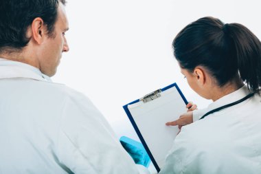 İki genç doktor işi tartışıyor, beyaz arka planda izole edilmiş.