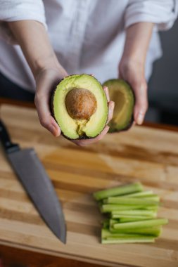 Ev mutfağında avokado kesen kadın aşçı.