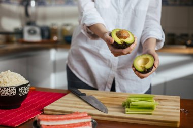 Ev mutfağında avokado kesen kadın aşçı.