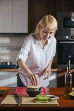 Kadın aşçı mutfakta suşi hazırlıyor.