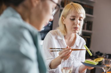 Akşam yemeğinde suşi yiyen iki arkadaş.