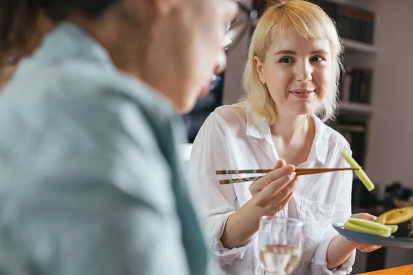 Two friends eating sushi for dinner at home