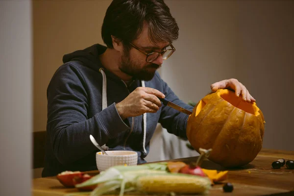 若いです男彫刻顔上のカボチャのためにハロウィン — ストック写真