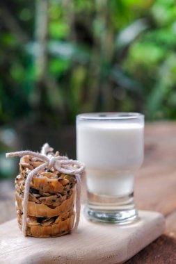 Tahtanın üzerinde bir bardak sütle fotokopi alanı olan bir yığın kurabiye.