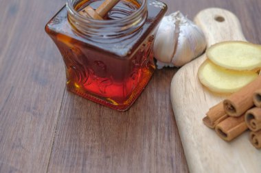 Beyaz arka planda izole edilmiş sarımsak, bal ve tarçınla alternatif tıp