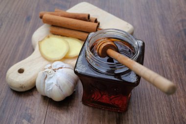 Beyaz arka planda izole edilmiş sarımsak, bal ve tarçınla alternatif tıp