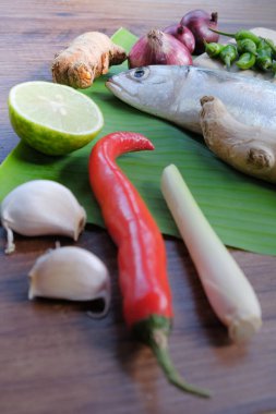 Ikan Pepes yapmak için baharatlı uskumru ya da ahşap masada muz yapraklarına sarılmış ızgara balık..