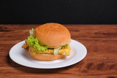 Ahşap arka planda yumurta burger.