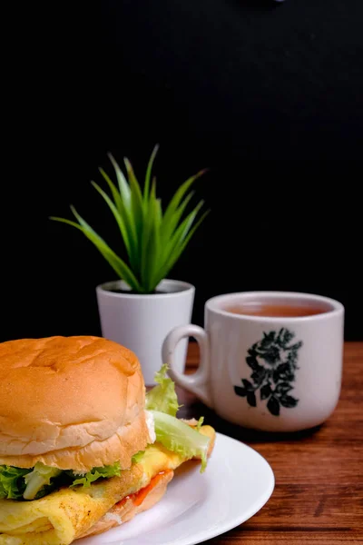 Eierburger Und Eine Tasse Tee Auf Holzgrund — Stockfoto