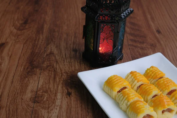 Traditional cookies in Malaysia during Hari Raya Festival known as Kuih tart or pineapples tart with lantern on the wodden background