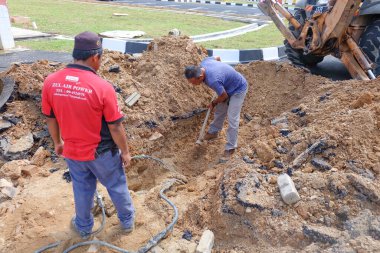 Muadzam Şah, Malezya - 31 Ocak 2020: Elektrik kablosu tamiri, altında hasar görmüş kabloyla açık siper .