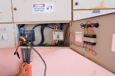 Elektrik panelinin önüne elektrik kablosu döşemek ve elektrik güç sistemini kontrol etmek için kablo döşemek.