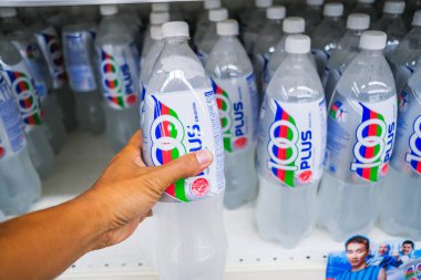 Senawang, Malezya - 8 Mart 2020: Süpermarket rafında 100 'den fazla izotonik karbonatlı içecek tutan adam.