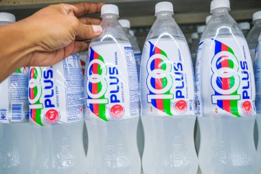 Senawang, Malezya - 8 Mart 2020: Süpermarket rafında 100 'den fazla izotonik karbonatlı içecek tutan adam.